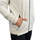 Close-up of a person wearing a textured white jacket with a hand in a pocket