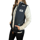 Person wearing a white fleece jacket under a black running vest with HC Run logo on left chest and hands in pocket