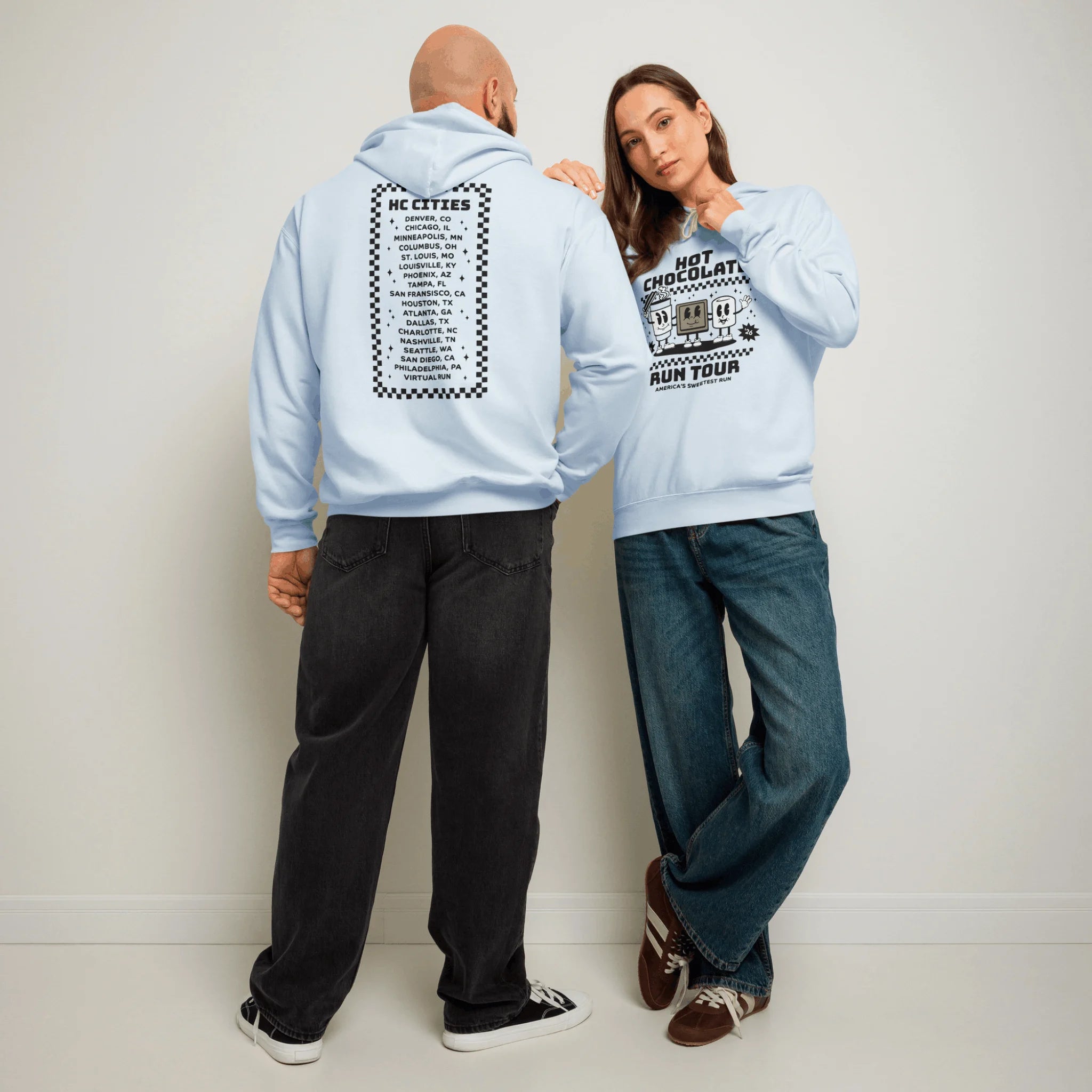 Woman and man wearing the light blue Hot Chocolate Run tour hoodies and jeans