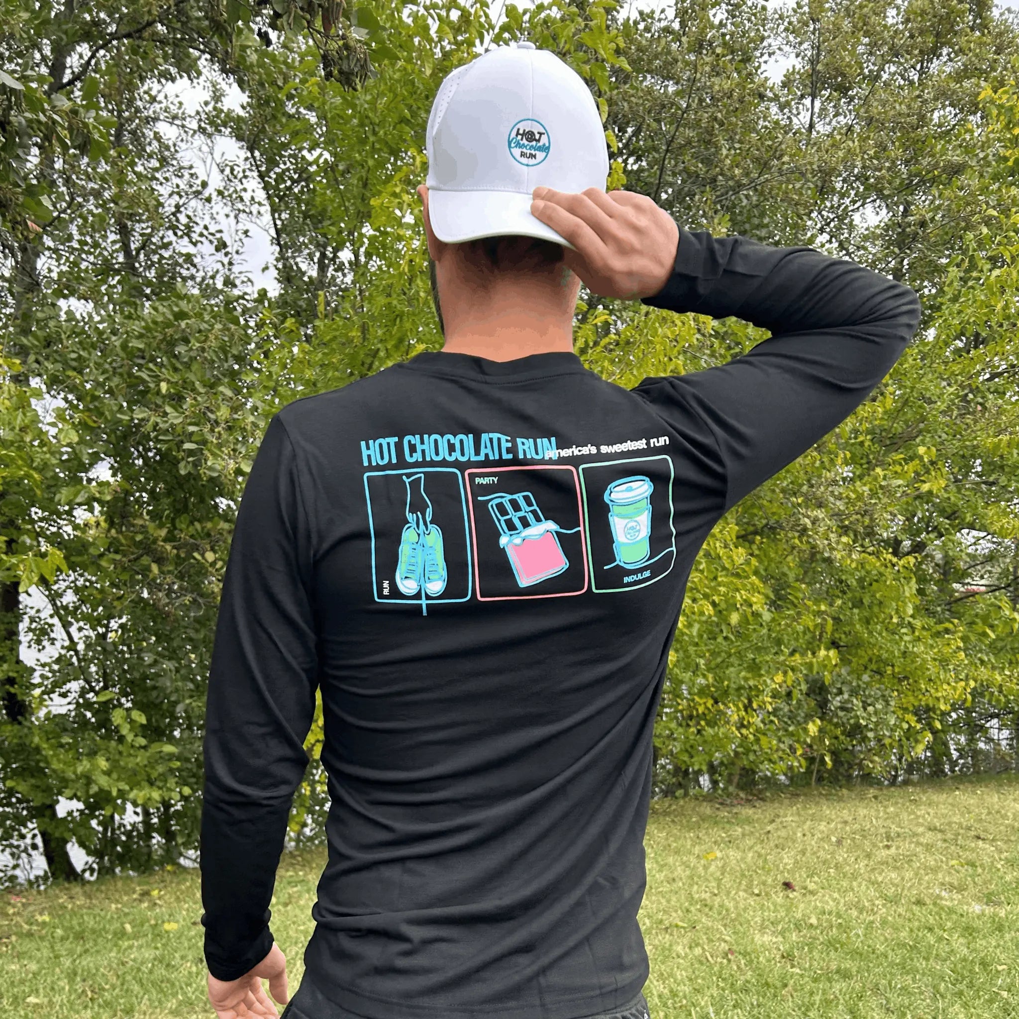 Man outside wearing white hat and black long sleeve with Hot Chocolate Run text and panel design