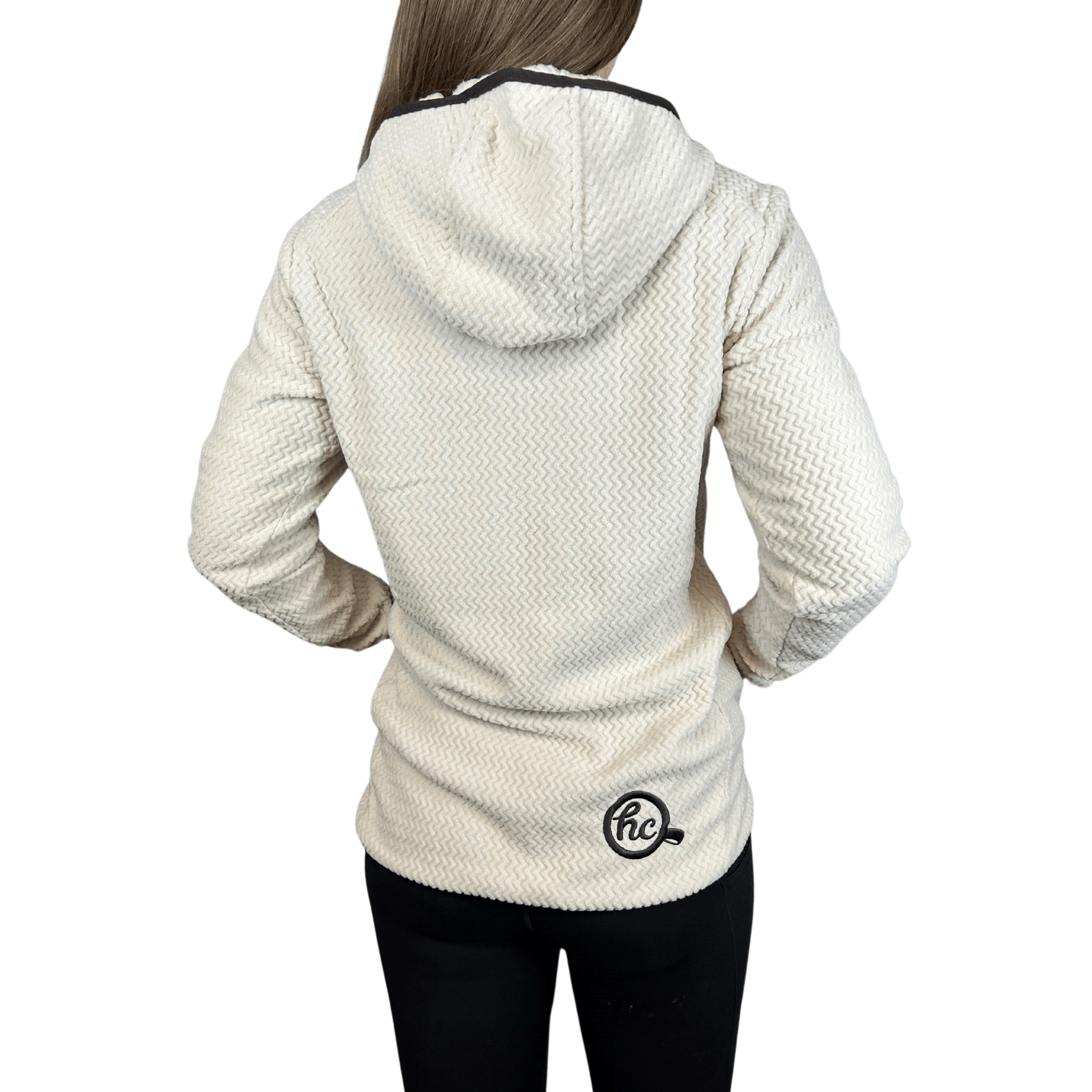 Person wearing a white textured fleece jacket with a logo on the back