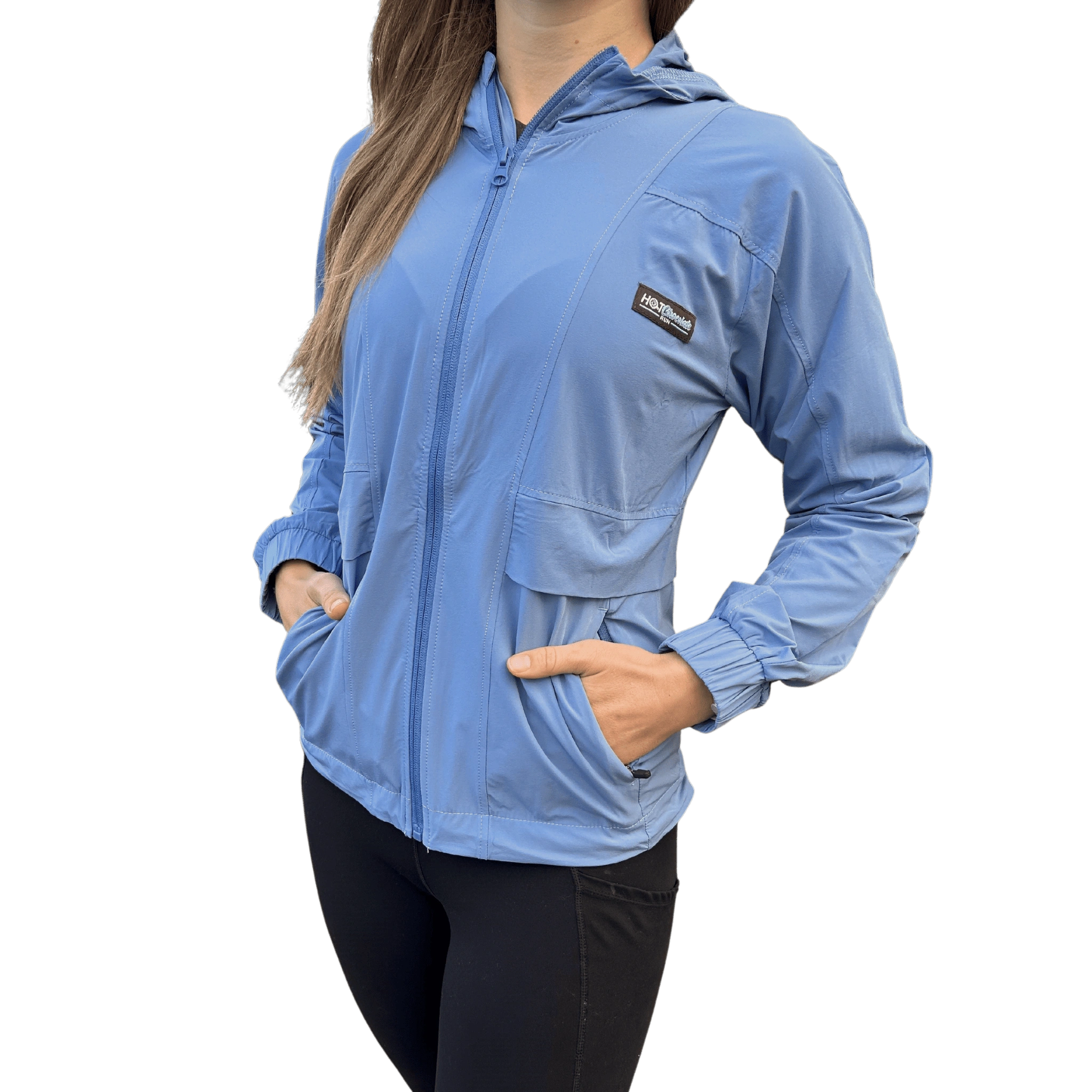 Person wearing a light blue jacket with hands in pocket and Hot Chocolate Run logo on left chest