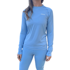 Woman wearing a light blue long-sleeve shirt with small Hot Chocolate Run logo on left chest