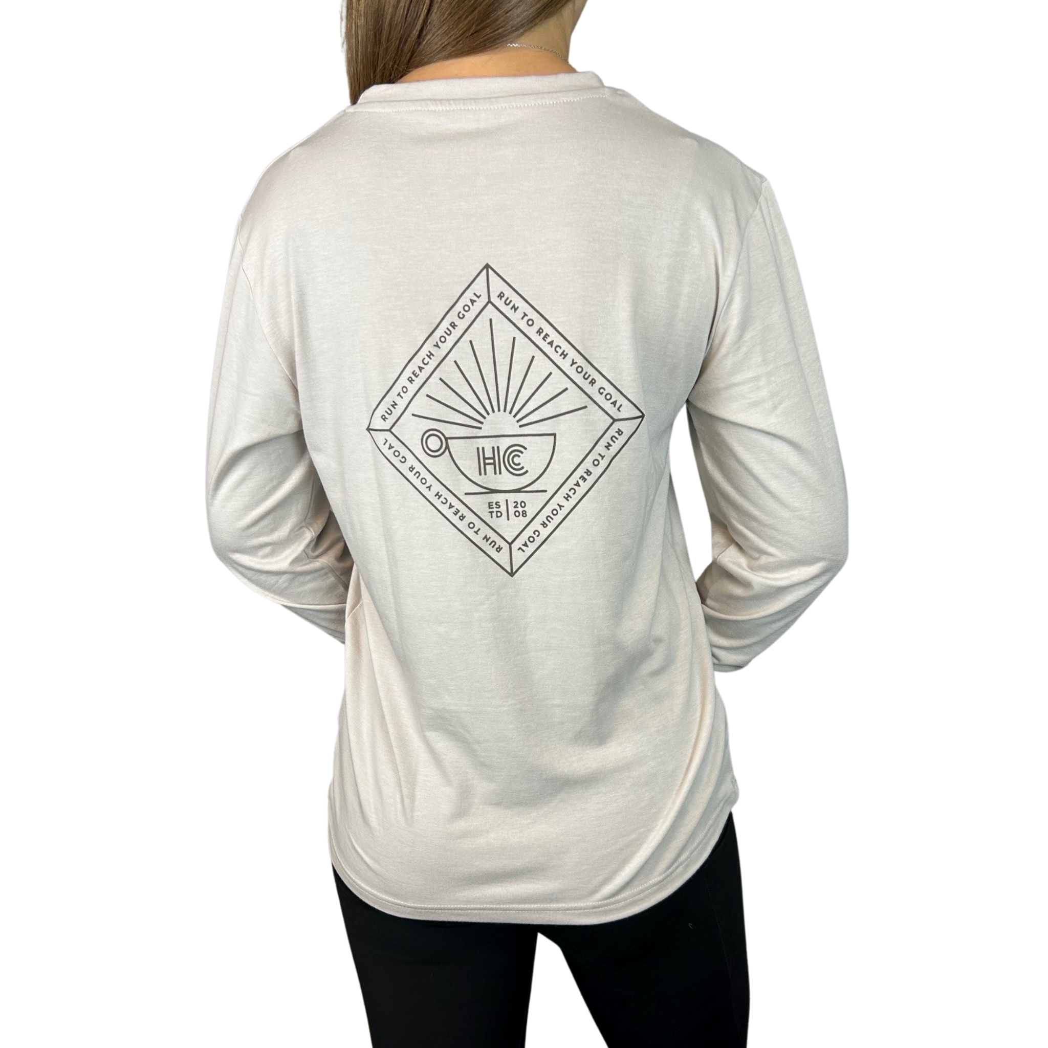 A person wearing a long sleeve light brown gray t-shirt with a graphic design