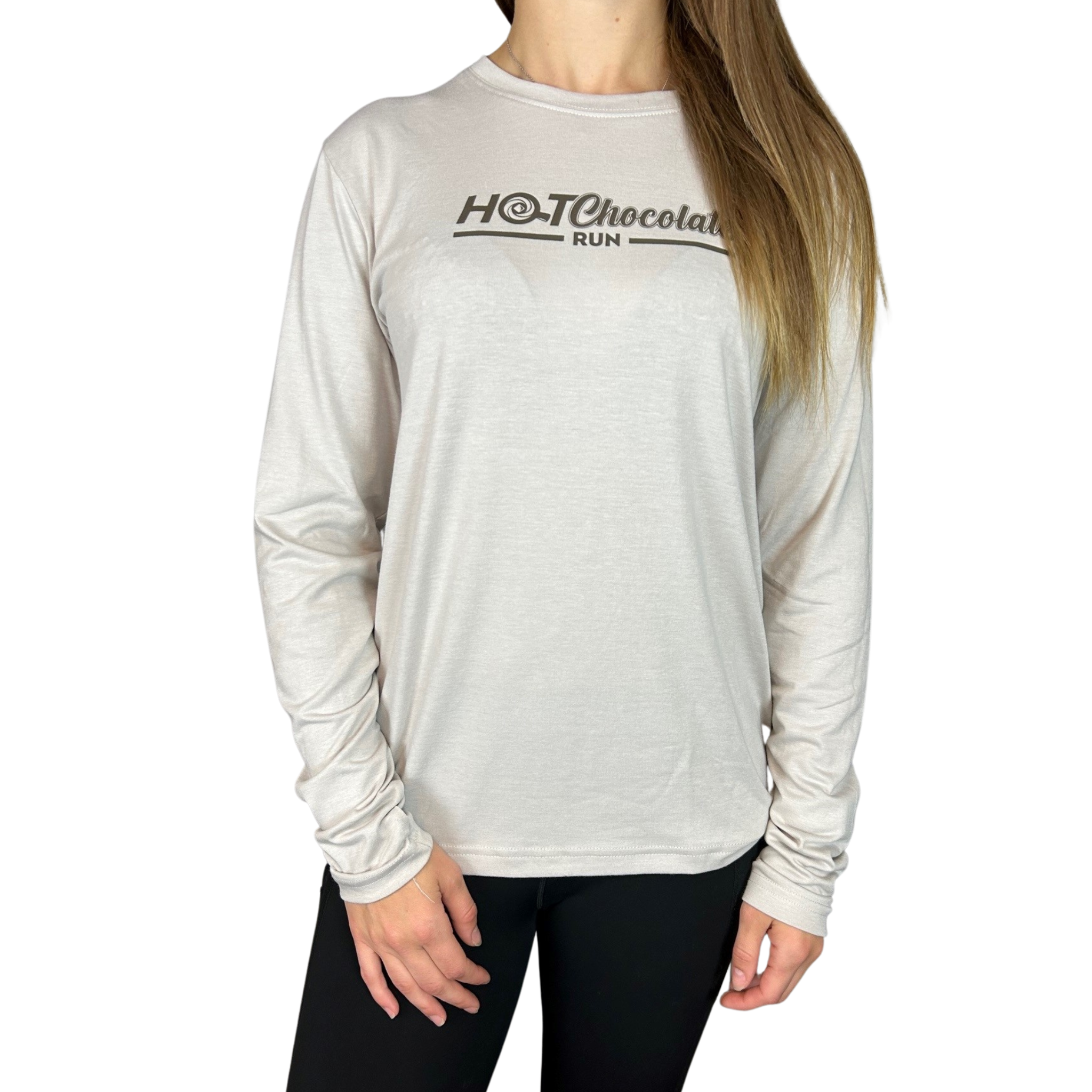 A person wearing a long sleeve light brown gray t-shirt with Hot Chocolate Run text in center chest
