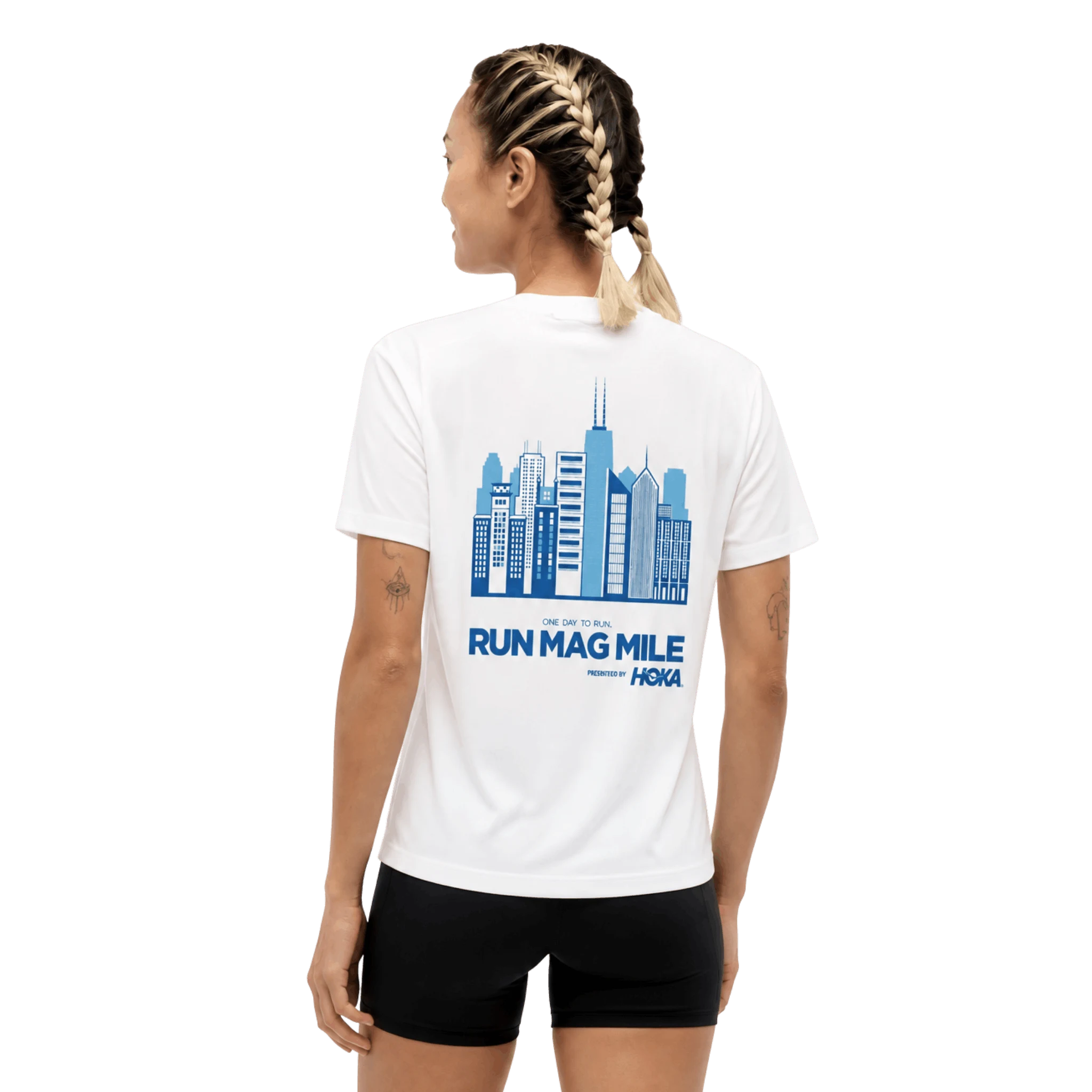 A woman shown from the back wearing a white short-sleeve T-shirt with a large blue Chicago skyline graphic and the text 'RUN MAG MILE' and 'HOKA' on the back